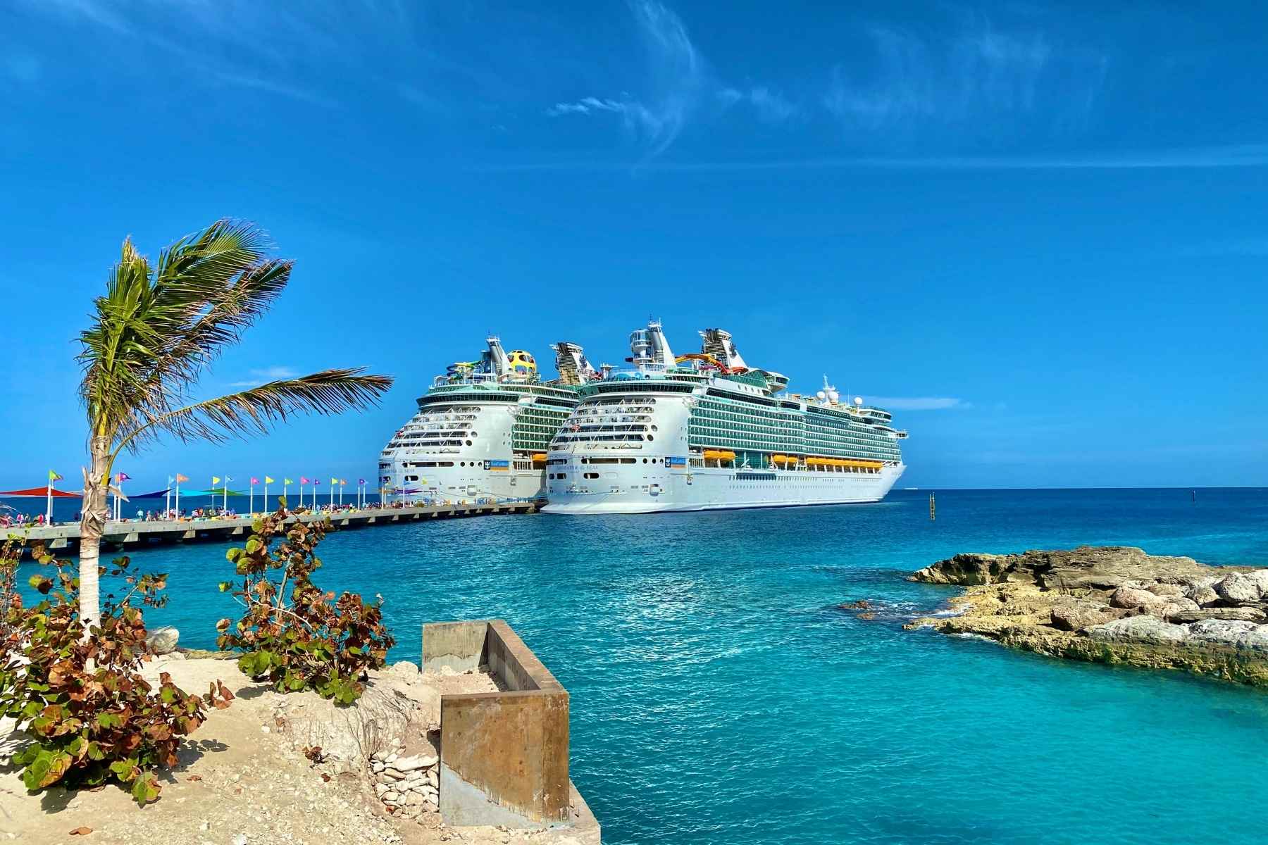 Two Royal Caribbean Cruise ships docked at a Caribbean Island port