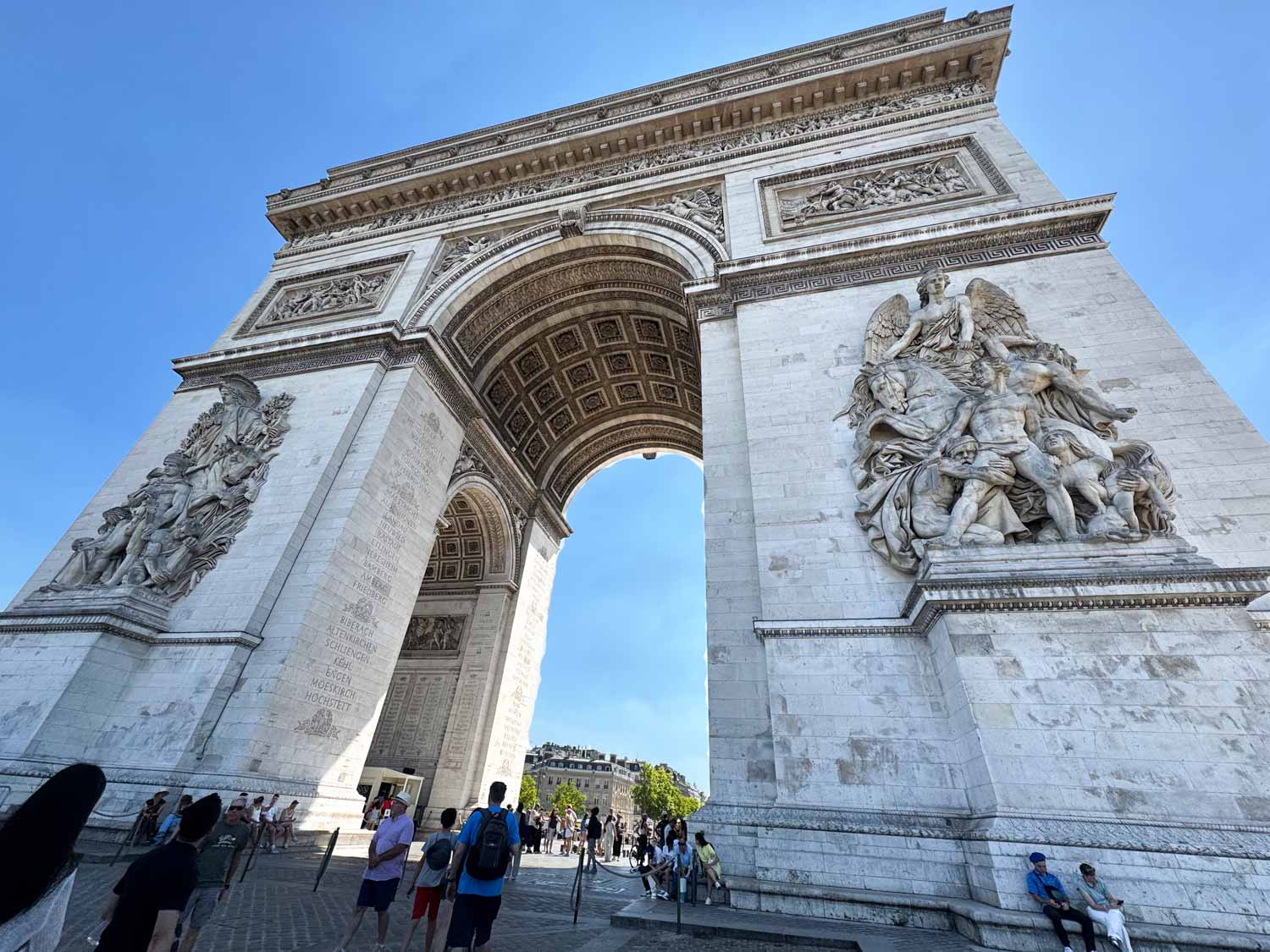 People beneath the Arc de Triomphe enjoying a guided tour.