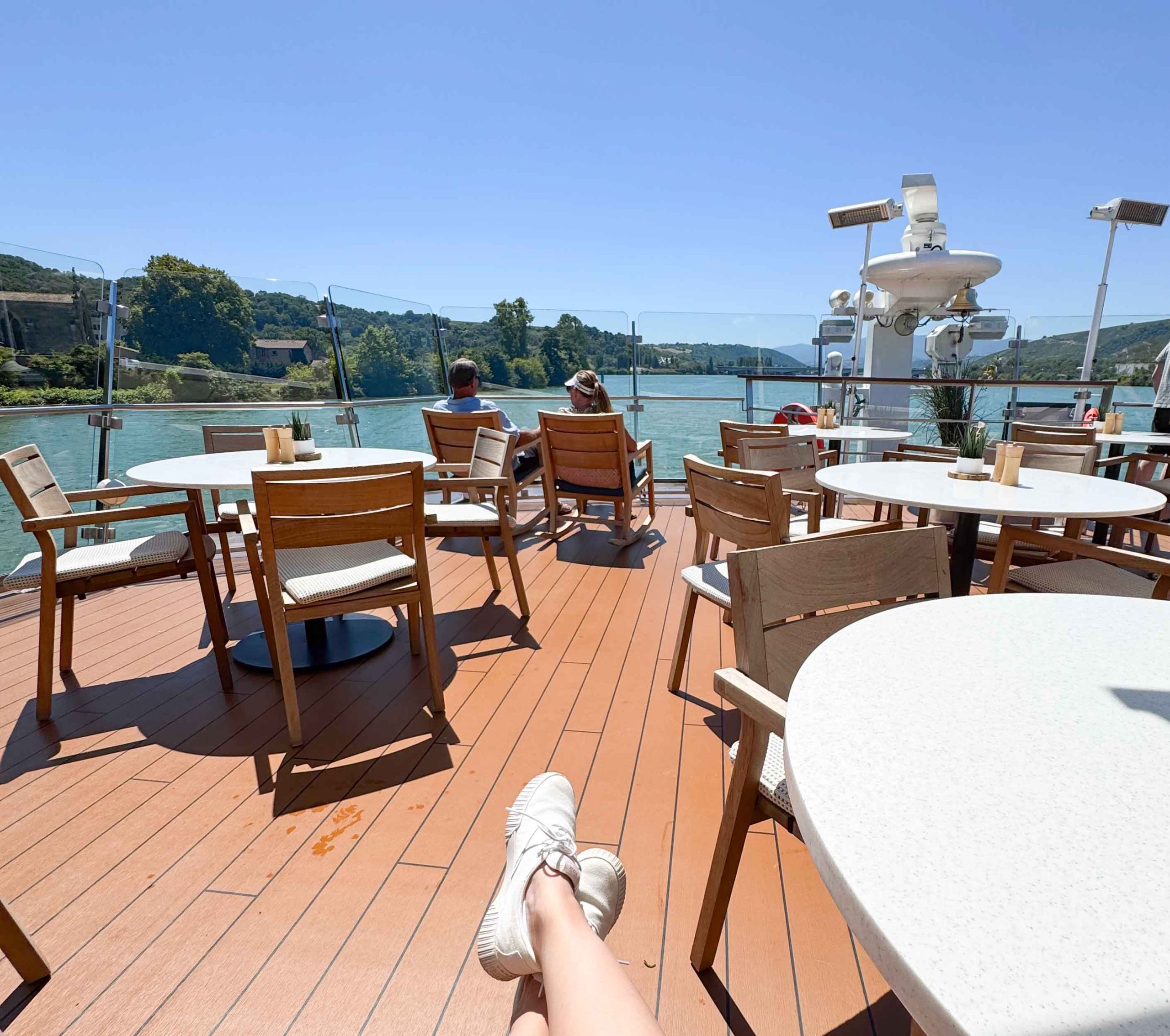 People sitting on the terrace of a river cruise watching the scenery.